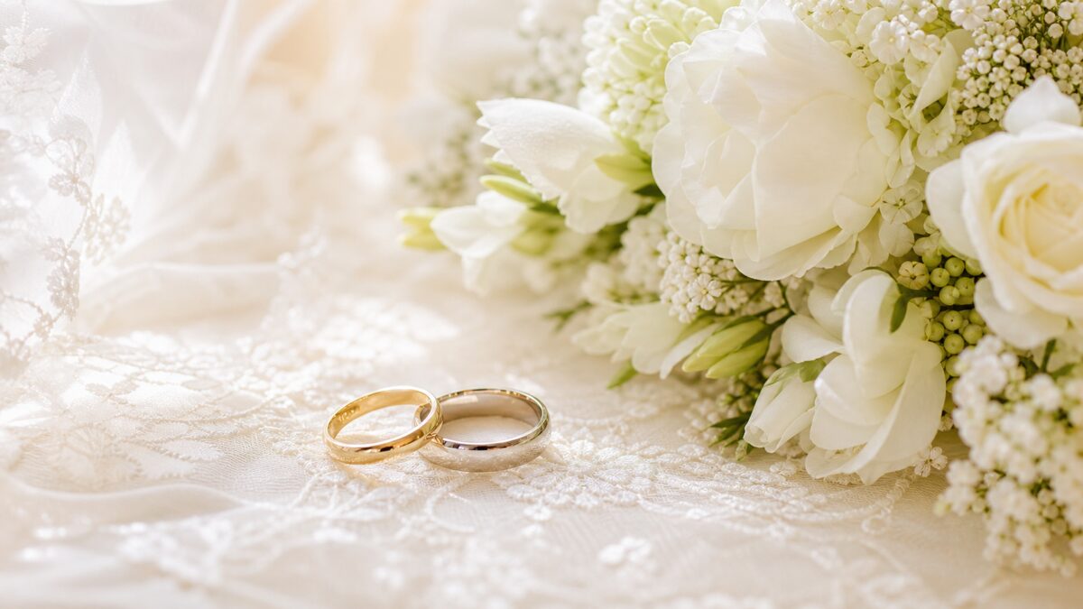 結婚指輪のペアと白いブーケ