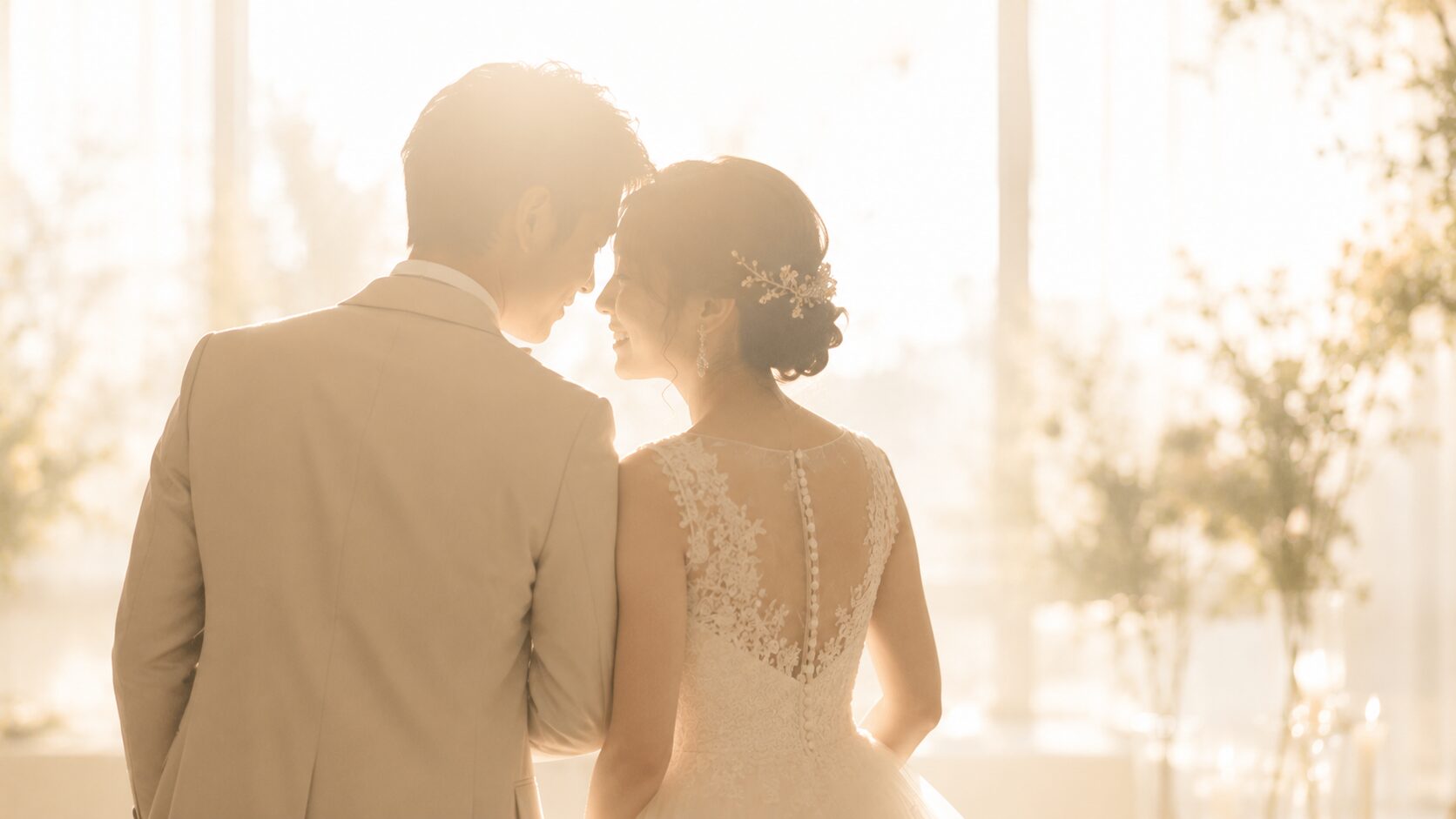 やわらかな光のなかで寄り添う新郎新婦の後ろ姿