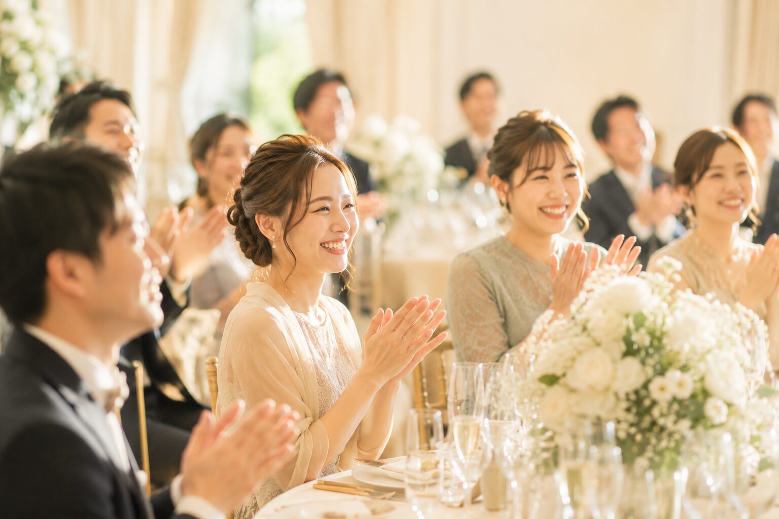 披露宴で笑顔で拍手するゲストたち